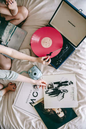 人在床上放鬆，有黑膠唱片和唱盤。 — 音樂美學 壁紙