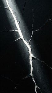 黑色表面帶有白色裂縫，形成抽象的幾何圖案