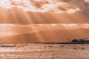 衝浪者在金色夕陽下乘風破浪，背景是山巒 — 唯美雲朵動態 壁紙