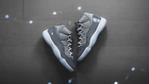 灰色Jordan 11波鞋在深色木上以藍光形成心形。