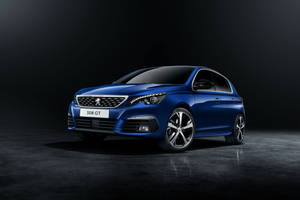 藍色Peugeot 308 GT跑車在攝影棚中，地板反光。