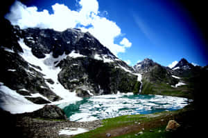 一個高海拔山湖，有正在融化的冰和白雪覆蓋的山峰，在明亮的藍天下。 — 湖 壁紙