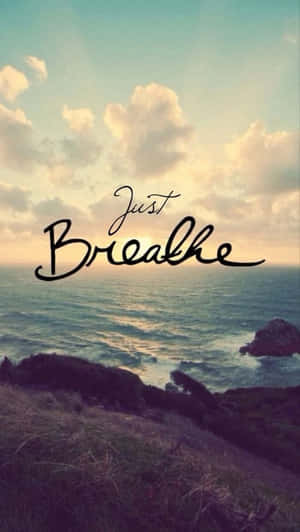 海岸日落場景，文字 just breathe 覆蓋在海洋和天空上。