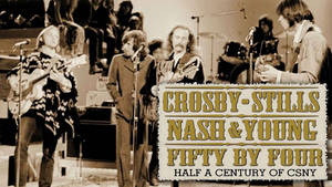 Crosby Stills Nash & Young 在舞台上用結他和擴音器現場表演。