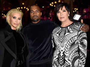 Kim Kardashian、Kanye West 和 Kris Jenner 在活動中一起擺姿勢。