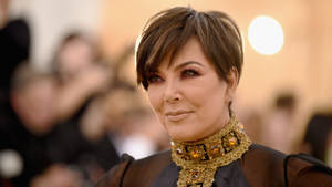 Kris Jenner 在華麗活動中佩戴金色珠寶頸鏈。