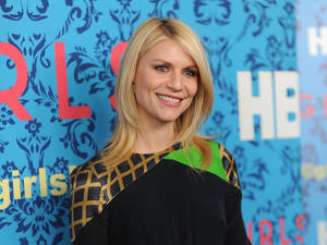 金髮女性在HBO Girls活動中穿著圖案上衣對著鏡頭微笑。