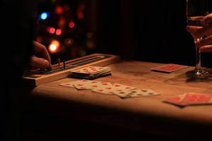 夜間在木桌上玩牌並移動遊戲棋子的雙手特寫。
