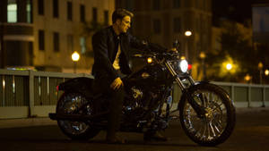 夜間城市中街燈下黑色電單車上的男子 — Harley Davidson 標誌 壁紙