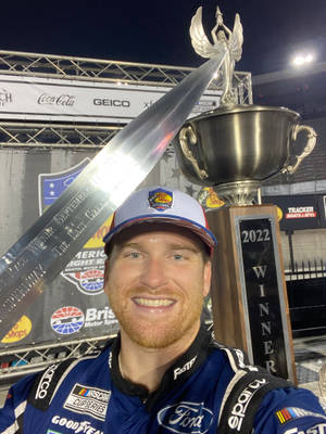 NASCAR車手在夜間活動中手持2022年冠軍獎盃。