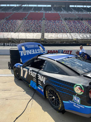 體育場維修區中打開引擎蓋的NASCAR賽車。