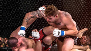 兩名男拳手在MMA籠內陷入纏鬥。
