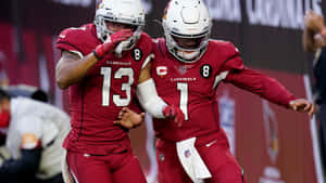 兩名身穿紅色球衣的美式足球員在球場上慶祝。 — NFL 美式足球 GIF 壁紙