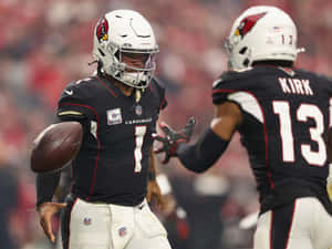 兩名身穿紅雀隊球衣的 NFL 美式足球運動員在比賽中。
