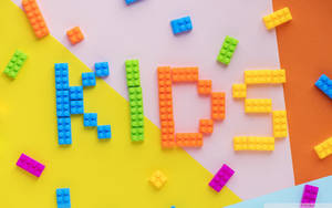 在幾何背景上拼出 kids 的彩色樂高積木。