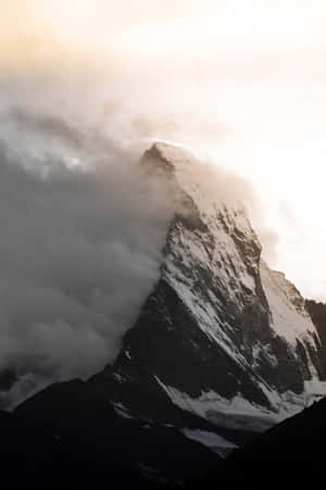白雪覆蓋的山峰從雲層中浮現，伴隨著金色陽光。