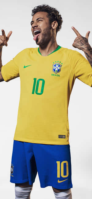 身穿巴西球衣的足球員尼馬（Neymar Jr.）做出和平手勢並伸出舌頭。