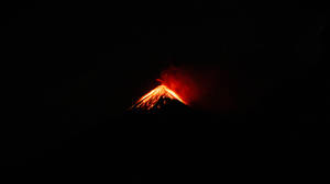 火山在繁星夜空下噴發著發光的熔岩。
