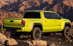 日落時分，岩石沙漠地形上的青檸綠色豐田 Tacoma TRD Pro 皮卡車。