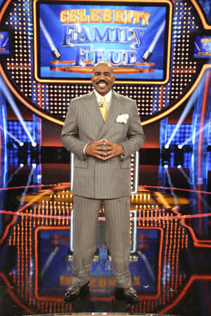 Steve Harvey在Celebrity Family Feud遊戲節目佈景中微笑，燈光璀璨。 — Huawei MatePad 11.5 (2025) 壁紙