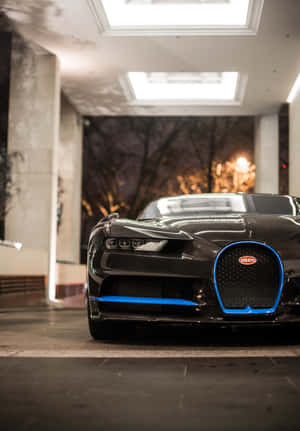 黑色 Bugatti 超級跑車帶有藍色飾邊，夜晚停放在室內天窗下。