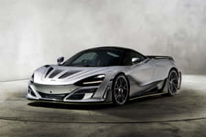 在混凝土工作室中，帶有黑色和黃色點綴的銀色McLaren超級跑車。