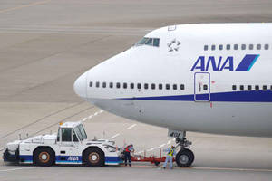 全日空飛機在機場停機坪上被地勤人員拖行。