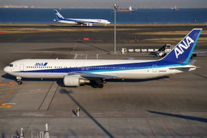 ANA飛機停泊在近海的機場停機坪上，可見船隻