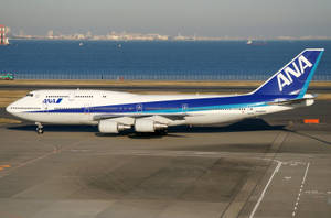 ANA波音747在機場跑道上，靠近海洋和城市