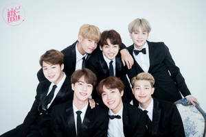 BTS 成員身穿黑色西裝望向鏡頭，K-Pop 代表團體