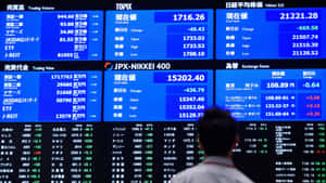交易員在東京證券交易所走過金融數據屏幕。