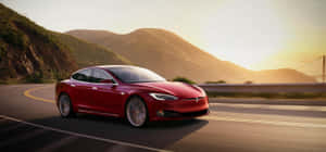 紅色Tesla Model S在日落時分沿海岸公路飛馳，背景有山脈和橋樑。 — Tesla GIF 壁紙