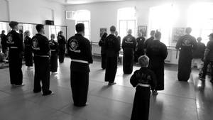 一群身穿黑色制服的武術學生站在道場中。