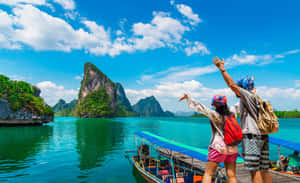 兩人在船上欣賞熱帶景色，有喀斯特地貌和清澈海水。