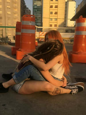 兩位頭髮色彩繽紛的女性在日落時分的城市人行道上擁抱。