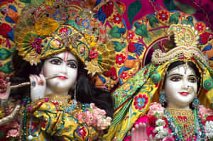 兩尊裝飾過的印度教神像，身著精緻的金色和花卉服飾。 — MacBook Air M2 壁紙