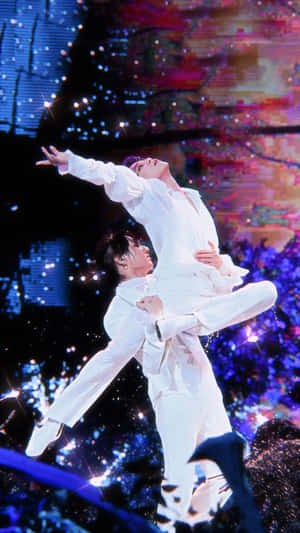 兩位身穿白色西裝的男舞者在閃爍的燈光下，於舞台上表演動態的托舉動作。 — iPhone 6 壁紙
