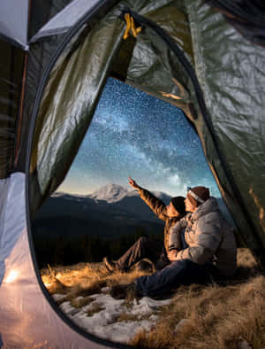 情侶在雪山上的帳篷中欣賞繁星點點的夜空。 — 露營 壁紙