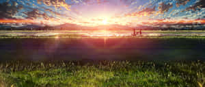 兩人在日落時分穿過草地，遠處有山脈。 — 2560x1080 壁紙