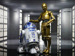 兩個星戰機械人R2D2和C3PO站在一個未來主義走廊中，帶有發光面板。 — 星際大戰 壁紙