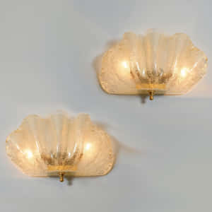 兩個復古玻璃貝殼壁燈，散發溫暖光線。 — iPad Air 11 壁紙