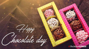 兩個裝滿各式朱古力的盒子放在木頭上，並有「Happy Chocolate Day」字樣。 — 朱古力 壁紙