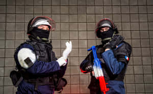 兩名戰術裝備的法國防暴警察，一人做手勢，另一人拿著彩色水槍。 — 虹彩六號：圍攻行動 壁紙