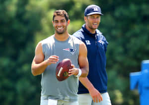 兩名身穿愛國者隊裝備的美式足球員在戶外訓練時微笑。 — NFL 美式足球 GIF 壁紙