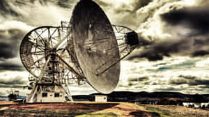 在多雲的天空下，偏遠戶外環境中的兩座大型無線電望遠鏡。 — 夜空 壁紙