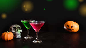 萬聖節主題飲品，在暗色表面上擺放南瓜和骷髏。 — 萬聖節恐怖 壁紙
