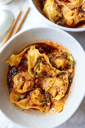 兩碗餃子配辣醬，飾以芝麻和青蔥。 — 2:3 壁紙