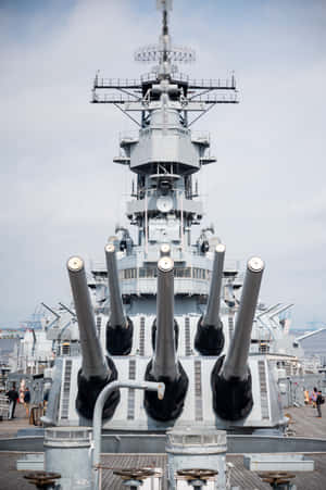戰艦炮塔的特寫，附近有人走動。 — 小米Pad 9 Pro 壁紙