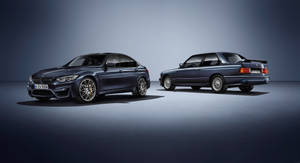 兩輛BMW房車，一輛現代一輛經典，並排展示在工作室中。