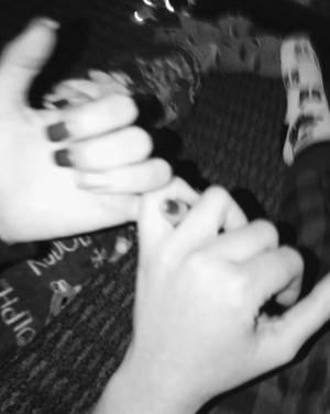 兩隻塗有深色指甲油的手在模糊的黑白照片中溫柔地觸碰。 — 黑白 壁紙